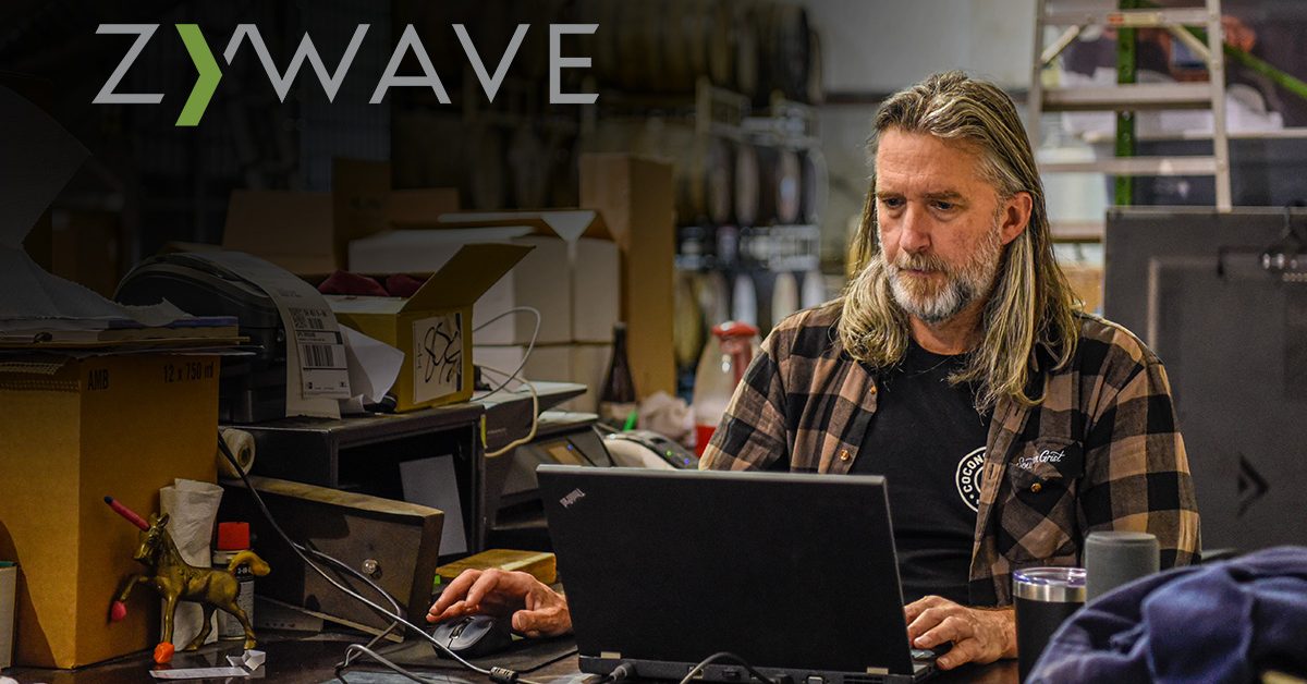 man working at computer in brewhouse with Zywave logo