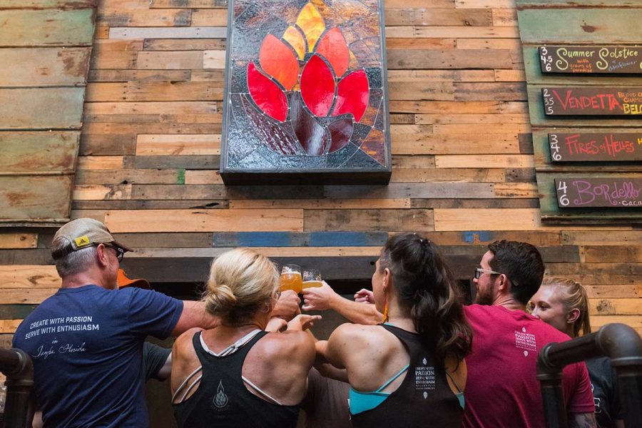Brewery patrons raising their glasses in a group cheers