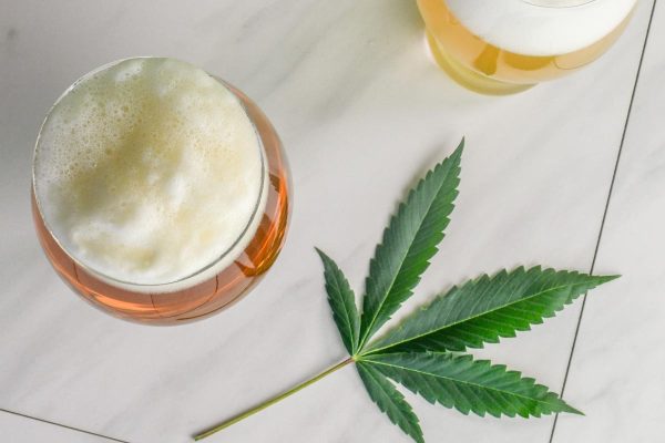 A hemp leaf next to two craft beers.
