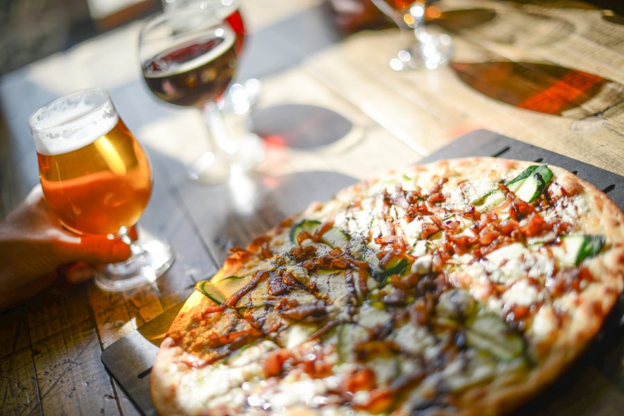 angled photo of pizza and beer on a wooden table
