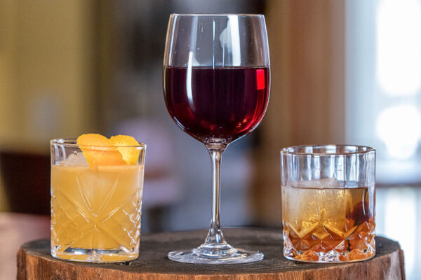 RTD cocktail, wine and whiskey on a wooden table.