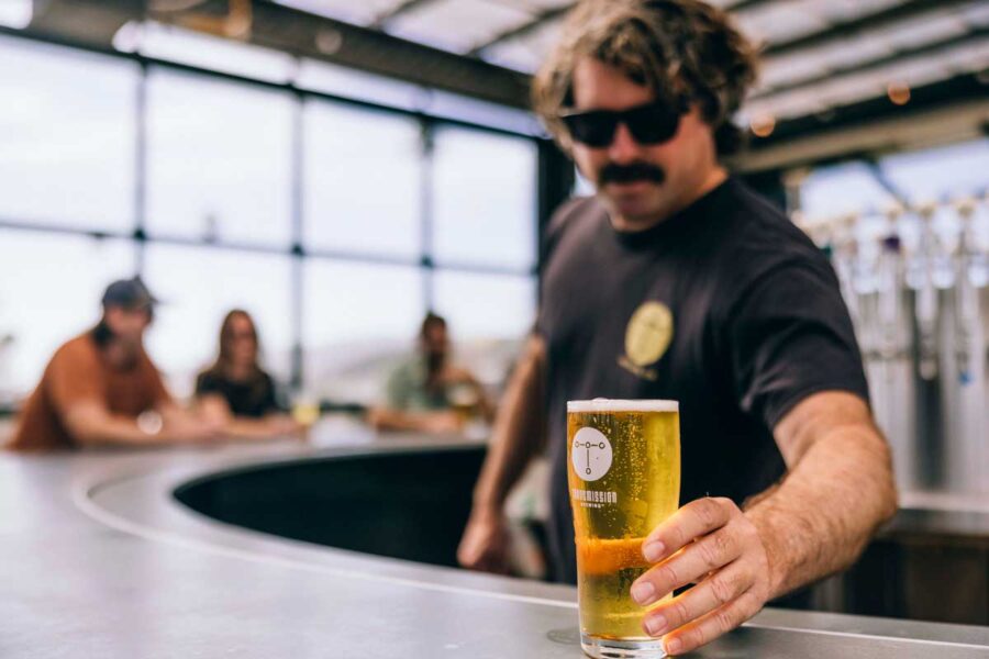 Beertender handing over a beer at the bar