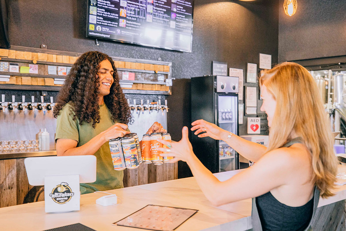 Passing craft beers over the counter.