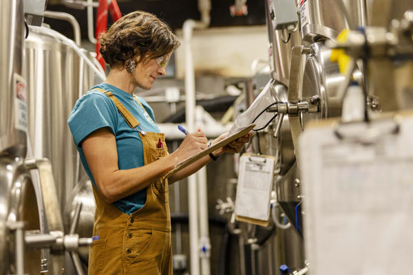 Employee with clipboard in brewery