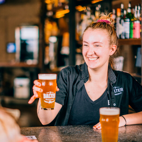 taproom bartender happily serving beer