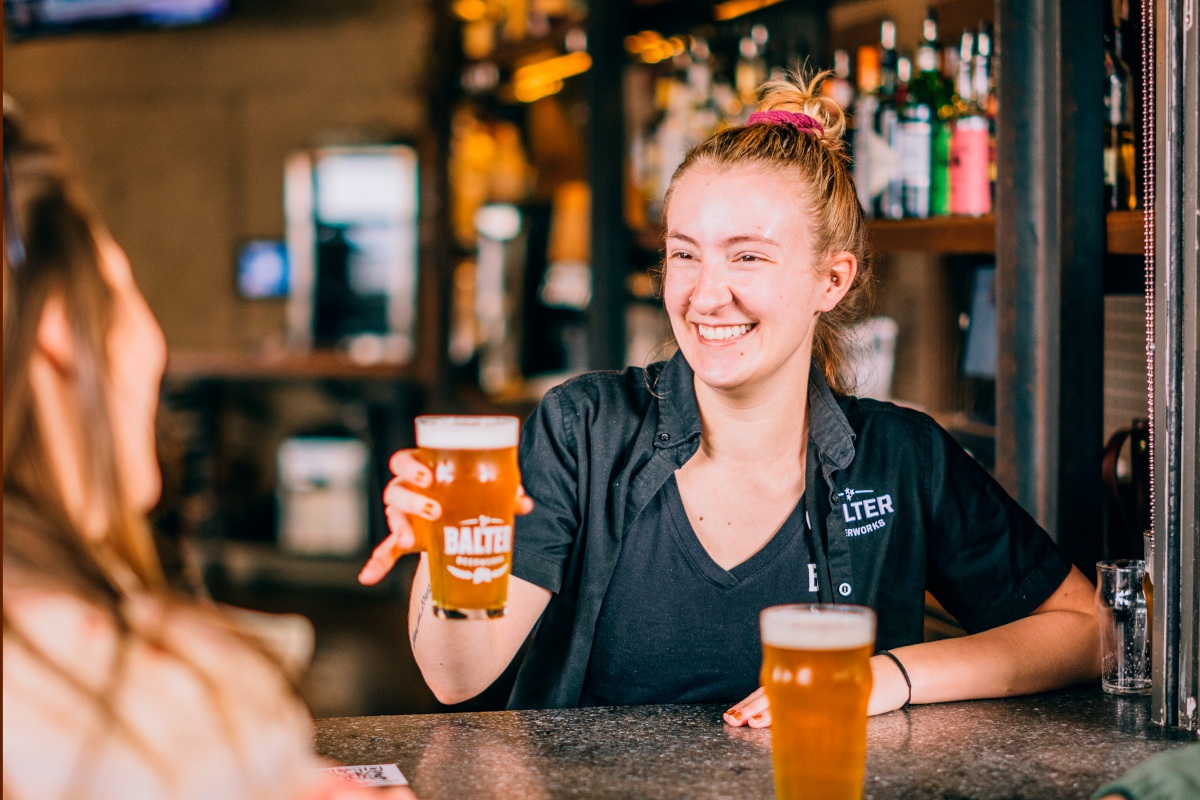 taproom bartender happily serving beer