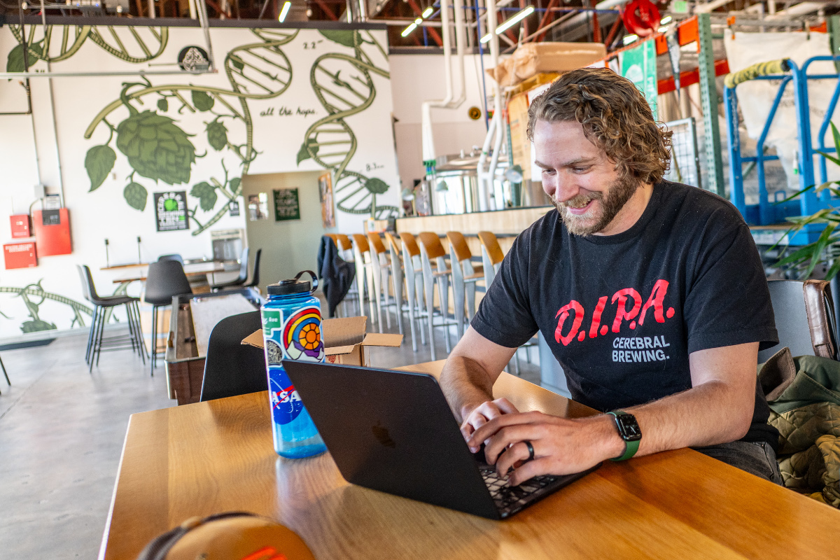 brewery staffer on a laptop in taproom