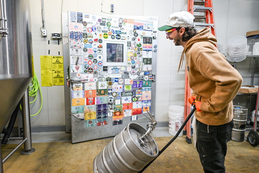 Brewer wheels a hand cart with a keg